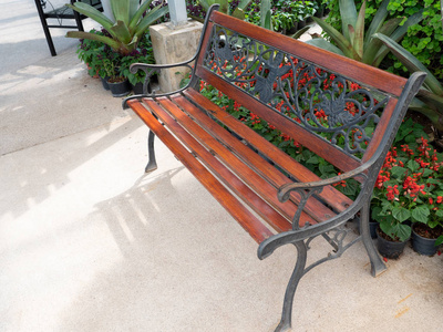 木制长凳，金属框架靠近植物园的混凝土通道。