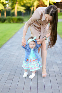与小女儿一起在公园散步的年轻女子