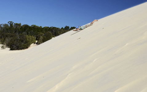 人在澳大利亚凯恩斯沙丘上冲浪。 人类在沙漠中进行极端的沙漠活动。 夏季活动。 休闲。 运动。 运动