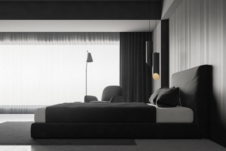 现代卧室的侧面视图，灰色墙壁，混凝土地板，灰色主床，灰色毛毯，床头柜和扶手椅。 3D渲染