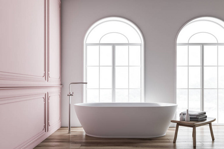 极简主义浴室的内部有粉红色和白色的墙壁，木制地板，拱形窗户和白色浴缸，旁边有带毛巾的木椅。 3D渲染