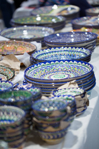 明亮的东方彩色盘子。 正宗的菜手画在民族风格。 东方集市上漂亮的碗和盘子。 明亮的背景说明民族东方风格。