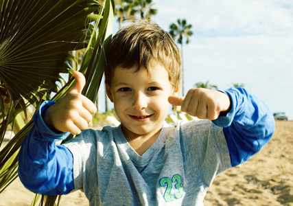 小可爱的真正的男孩在玩石头海海岸大拇指