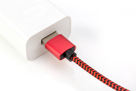 USB电缆进入墙壁充电器隔离在白色背景。