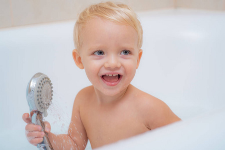 儿童泡泡浴。漂亮的微笑的小男孩洗澡用肥皂苏打水。可爱的小男孩洗。洗澡时的孩子