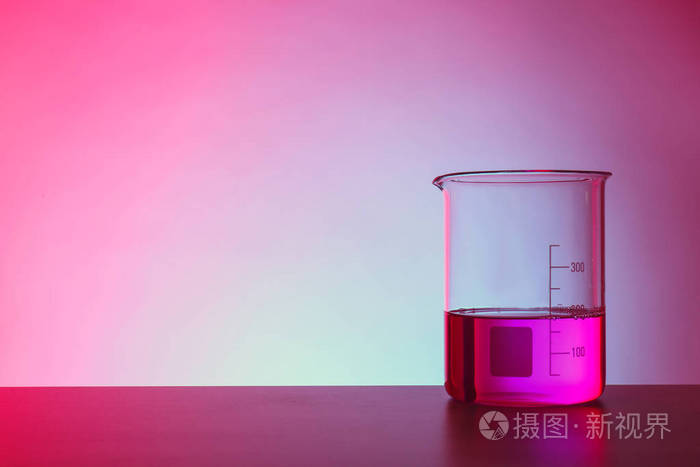烧杯,桌子上有液体,背景为彩色 化学实验室玻璃制品