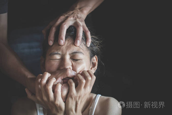 一个男人在黑暗中伤害一个被吓坏的女人的家庭暴力停止了对女人的家庭