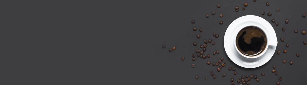 平躺杯黑色咖啡和咖啡豆在灰色的深色背景顶部视图复制空间。 简单的食物概念早晨早餐时间工作热饮咖啡背景