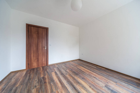 空荡荡的明亮客厅。 新的家庭内部。 木制地板。
