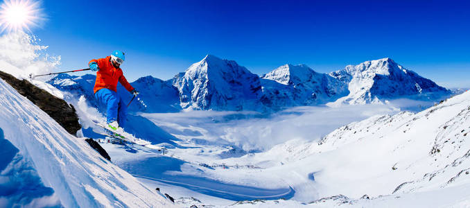 登山者沿着雪山脊滑雪。 在背景蓝天和闪亮的太阳和奥特勒在南蒂罗尔意大利。 冒险冬季极限运动。