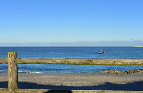 有木栅栏和渔船的海滩。 晨光晴天蓝天。 加利西亚科鲁纳西班牙。