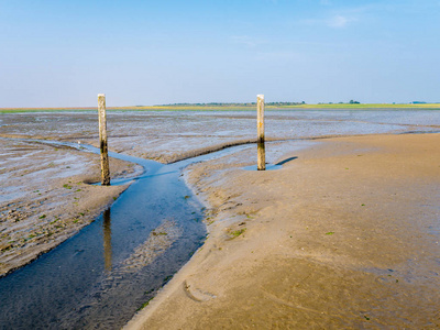 荷兰西弗里斯兰岛施埃蒙尼科奥格岛附近的瓦登海低潮时用木杆标出的泥滩和潮汐