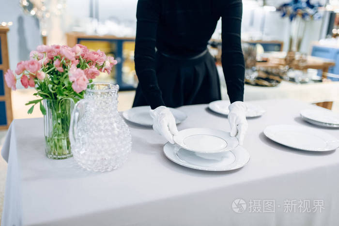 服务员把盘子放在宴会上,摆好桌子.服务,节日宴会装饰