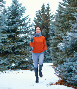 女人在冬天奔跑，森林里美丽的风景和雪杉树