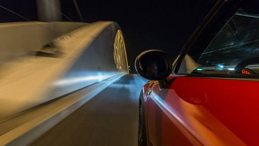 汽车在夜间街道上以快速的速度移动，时间推移过高的漂移。 道路模糊，灯光从汽车高速反射。 捷克语