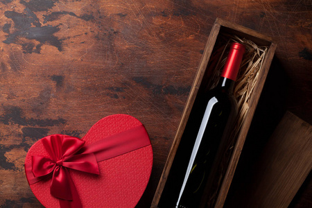 s day greeting card with red wine bottle and gift box on wooden 