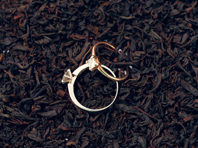红茶叶的背景。 珍贵的戒指。 装饰品