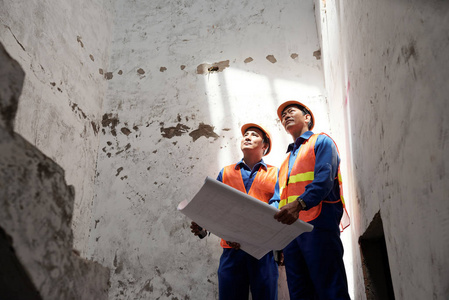 建筑工程师站在墙上，讨论重建问题