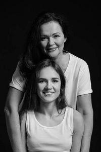 黑白相间的年轻女子与母亲在黑暗背景下的肖像