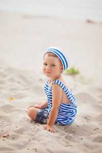 s undershirt and cap sits on the sea beach, summer background