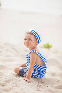 s undershirt and cap sits on the sea beach, summer background