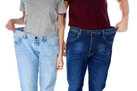 适合穿超大牛仔裤的人在白色背景特写。 重量损失