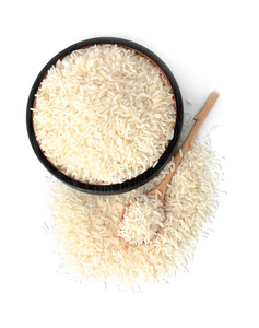 白色背景上的平板勺子和未煮熟的长粒大米
