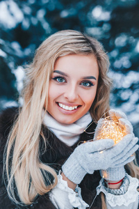 冬日森林中美丽少女的圣诞画像，灯火辉煌