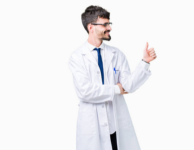 年轻的职业科学家，穿着白色外套的男人，在孤立的背景下，看着骄傲的微笑，竖起大拇指，向旁边做手势