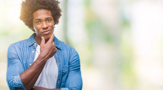 美国黑人男子在孤立的背景上自信地看着相机，微笑着交叉的手臂和举起的手在下巴上。 积极思考。