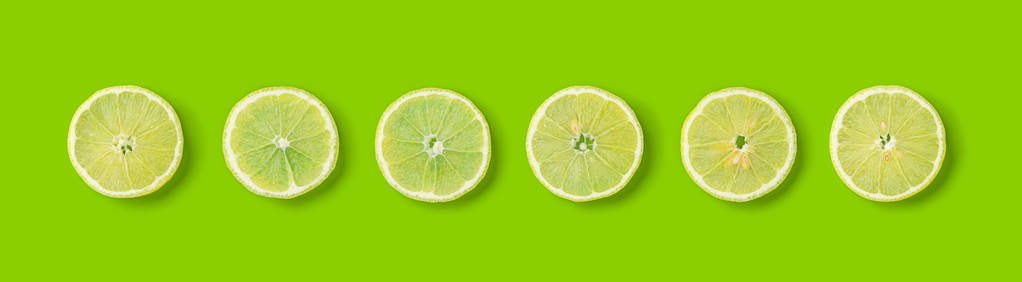 绿色背景上柠檬片的水果图案。 平躺顶部视图。 横幅无缝图案创意夏季食品概念。