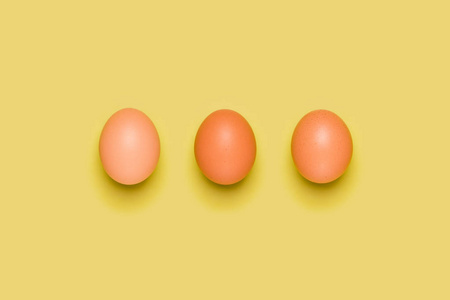 黄色背景上的鸡蛋图案。 复活节的概念。 平躺顶部视图。 食物背景。