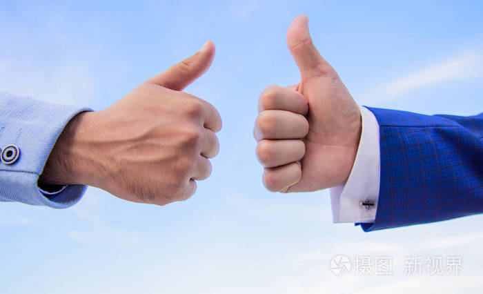 手放在蓝天背景上男性手显示竖起大拇指的标志成功和认可的概念手势
