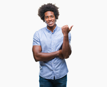 美国黑人男子在孤立的背景上微笑，快乐的脸，看和指向一边，拇指向上。
