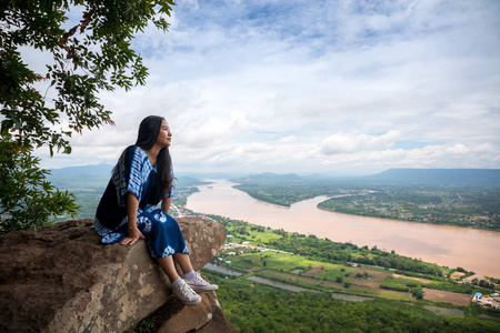 年轻女子坐在泰国福星山顶上