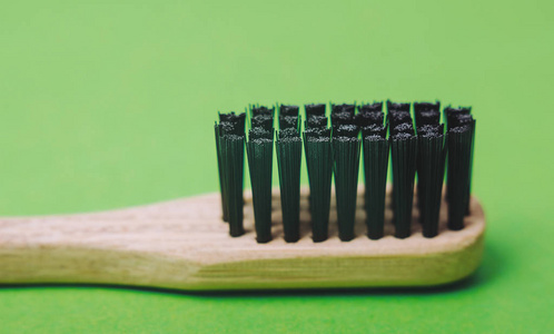 竹制牙刷，特写，绿色背景隔离
