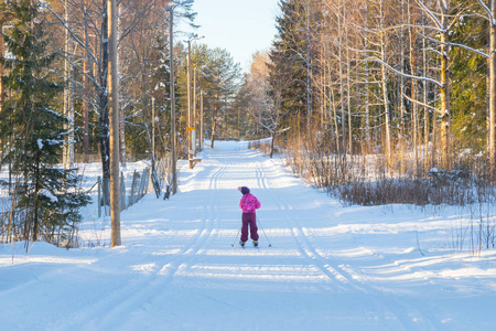 芬兰冬季森林滑雪跑道上的小孩。