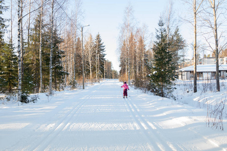 芬兰冬季森林滑雪跑道上的小孩。