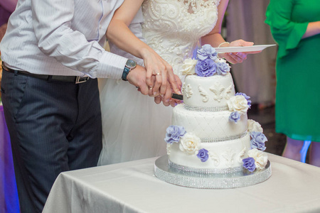 新郎新娘用刀把婚礼蛋糕切碎