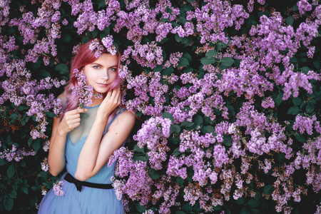 紫丁香花园里穿漂亮衣服的女孩的美术肖像。