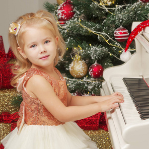 钢琴和圣诞树附近的小女孩