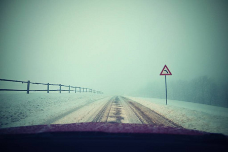 冬天开车。 从一辆汽车的内部观看雪道上的司机的眼睛。 冬季驾驶安全的概念。