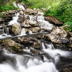 山上的瀑布。 河流中的快速流动。 岩石中的水沿河而行。