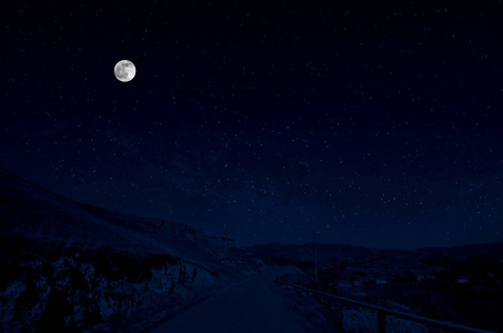 满月之夜，山路穿过森林。 夜晚风景优美的乡村道路，有大月亮