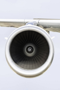 飞机机翼上的喷气发动机。 关闭喷气发动机的正面视图和背景上的天空。 空运概念。