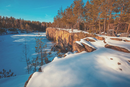 冬天的自然。花岗岩岩石冻湖岸..晴天的花岗岩采石场