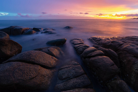 海浪冲击岩滩日落美丽的自然夏季海景泰国。