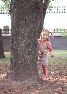 快乐的小女孩玩捉迷藏在城市公园