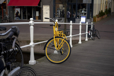 黄色自行车停在荷兰莱顿的桥上