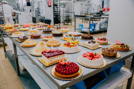 在食品厂的金属桌上准备了许多不同的蛋糕